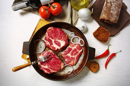 Marbled beef steak and wine bottle on wooden backgroundの写真素材