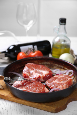 Marbled beef steak and wine bottle on wooden backgroundの写真素材