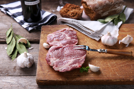 Marbled beef steak with bottle of wine and spices on wooden backgroundの写真素材
