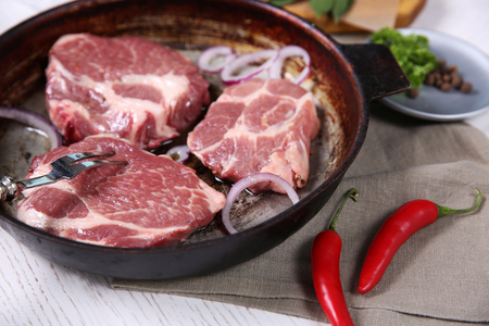Marbled beef steak on pan and spices on color wooden backgroundの写真素材