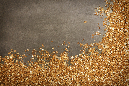 A corner of Gold nugget grains, on cement backgroundの写真素材