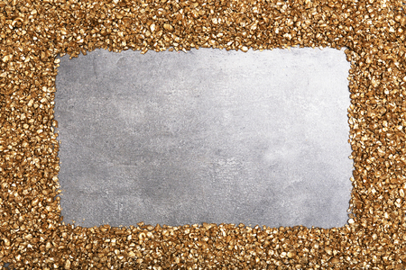A frame of Gold nugget grains, on cement backgroundの写真素材