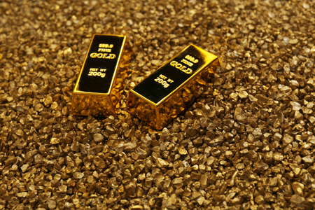 Gold bars on nugget grains background, close-up