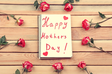 Notebook with text HAPPY MOTHER'S DAY on wooden backgroundの写真素材