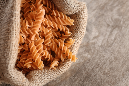 Bag with uncooked pasta on tableの写真素材