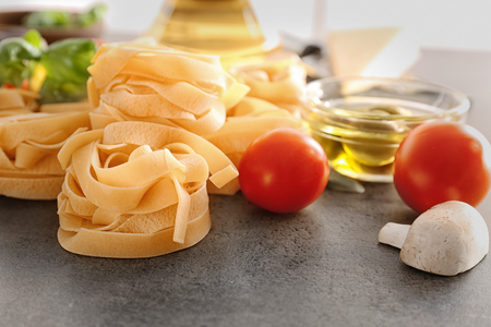 Uncooked fettuccine pasta and products on tableの写真素材