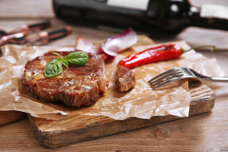 Roasted beef fillet and vegetables on cutting board, on wooden backgroundの写真素材