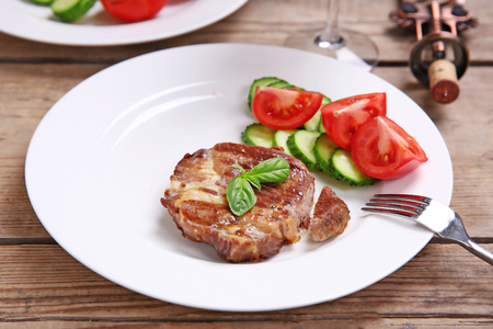 Roasted beef fillet and fresh vegetables on plate, on wooden backgroundの写真素材