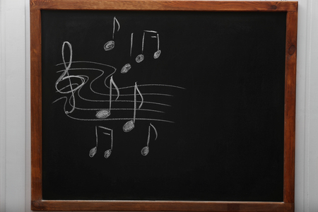 A blackboard with musical notes on the wall in the classroomの写真素材