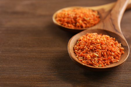 Two wooden spoons with spice on the table, close-upの写真素材