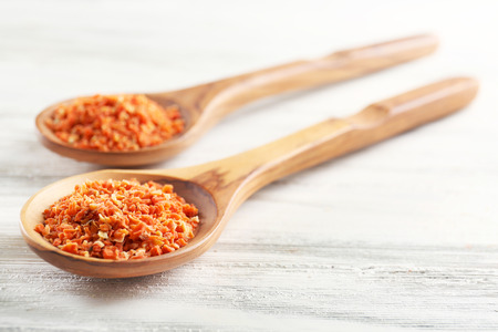 Two wooden spoons with spice on the table, close-upの写真素材