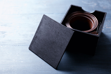 Leather belt with buckle in gift box on wooden backgroundの写真素材