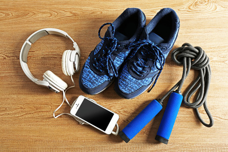 Sport shoes, equipment and smart phone with headphones on light backgroundの写真素材