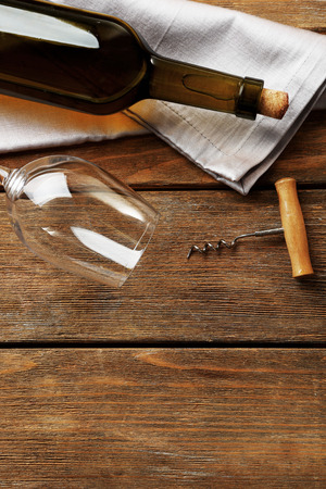 Bottle of wine with glass and corkscrew on wooden backgroundの写真素材