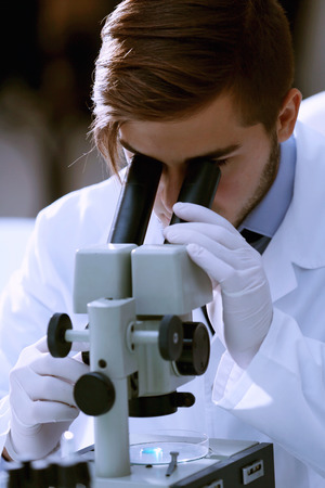 Serious clinician studying chemical element in laboratoryの写真素材