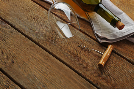 Bottle of wine with glass and corkscrew on wooden backgroundの写真素材