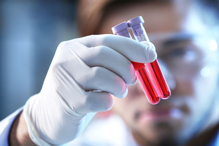 Man in laboratory checking test tubesの写真素材