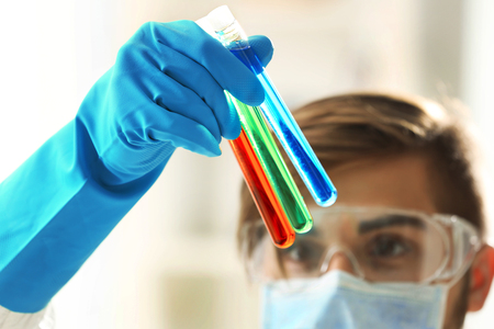 Man in laboratory checking test tubesの写真素材