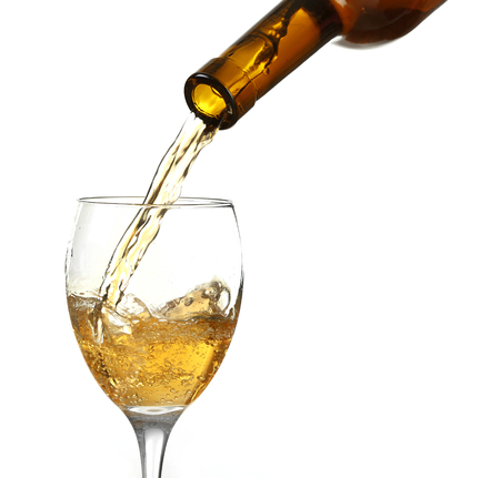 White wine pouring in glass, isolated on whiteの写真素材