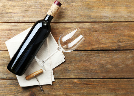 Bottle of wine with glass and corkscrew on wooden backgroundの写真素材