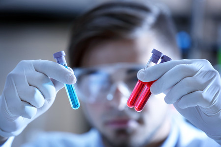 Man in laboratory checking test tubesの写真素材