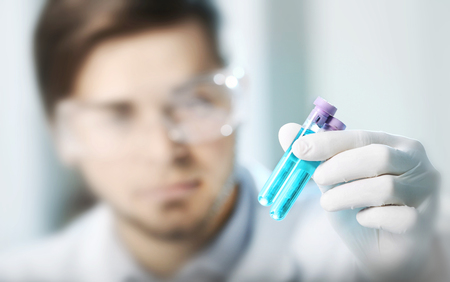 Man in laboratory checking test tubesの写真素材