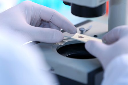 Serious clinician studying chemical element in laboratoryの写真素材