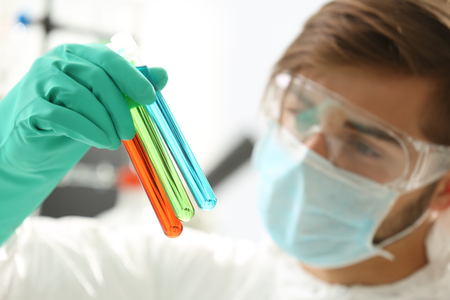 Man in laboratory checking test tubes