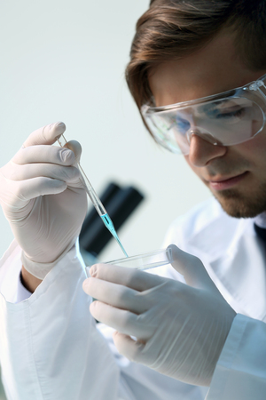 Serious clinician studying chemical element in laboratoryの写真素材