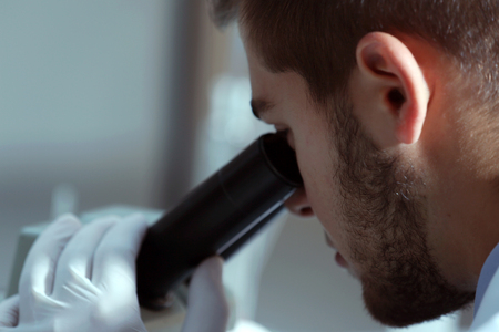 Serious clinician studying chemical element in laboratoryの写真素材