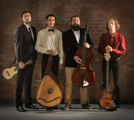 Man's musical band on brick wall background in the studio