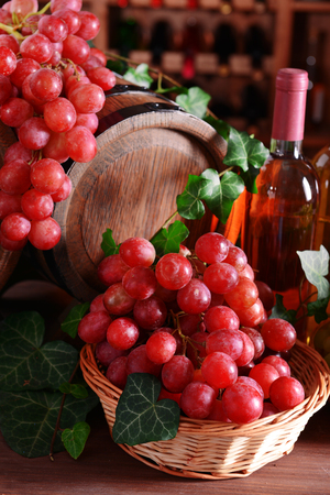 Grapes with wine and barrel on tableの写真素材