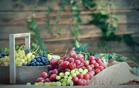 Grape in wooden box on a tableの写真素材