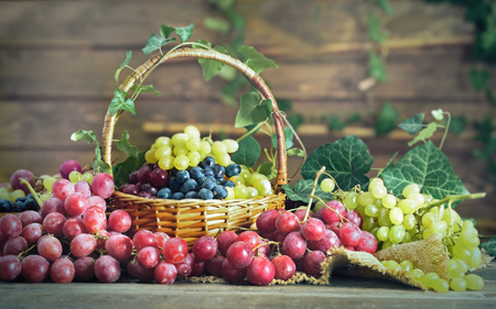 Grape in basket on wooden tableの写真素材