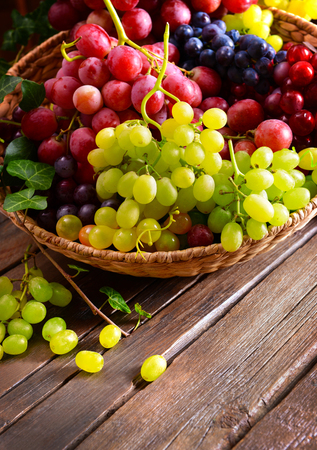 Grape in basket on wooden tableの写真素材