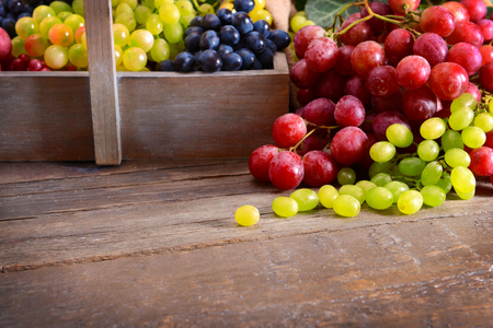 Grape in wooden box on a tableの写真素材
