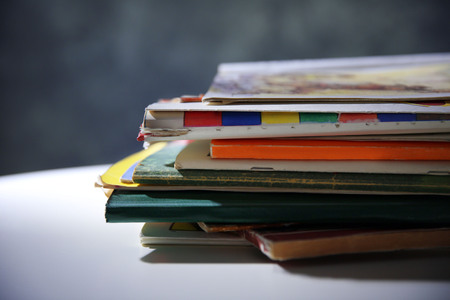 Pile of books on the table against grey wall, close upの写真素材