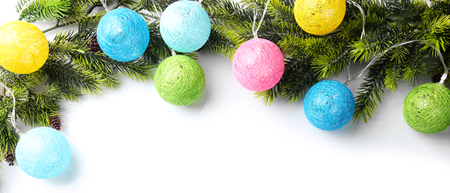Christmas tree branch decorated with colourful lights on white background