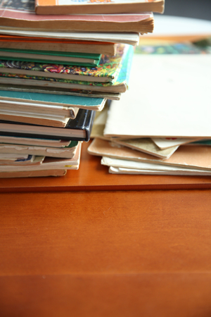 Pile of old books on brown table in the roomの写真素材
