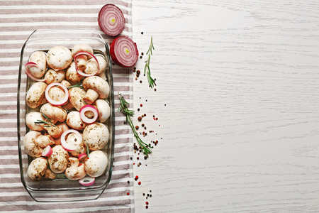 Marinating mushrooms with spices on wooden tableの写真素材