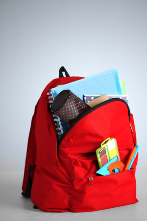 Backpack with school supplies on wooden tableの写真素材
