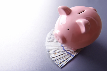 Pig moneybox and euro banknotes on wooden backgroundの写真素材
