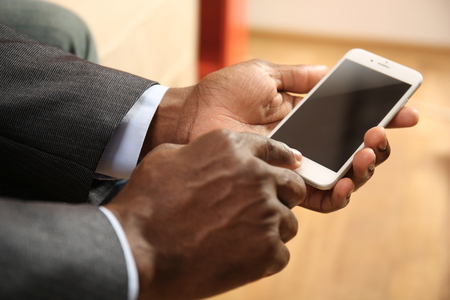 Afro american man with a smartphone indoorの写真素材