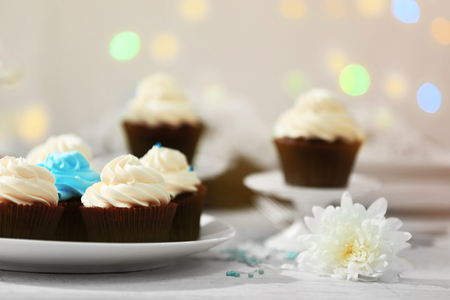 Chocolate cupcakes and flowers on a tableの写真素材
