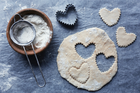 Uncooked heart shaped biscuits on a tableの写真素材