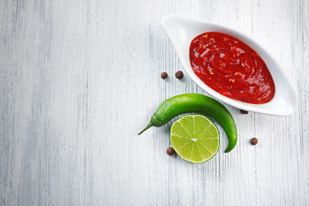 Homemade hot sauce and spices on light wooden backgroundの写真素材