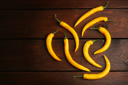Yellow chili peppers on wooden backgroundの写真素材