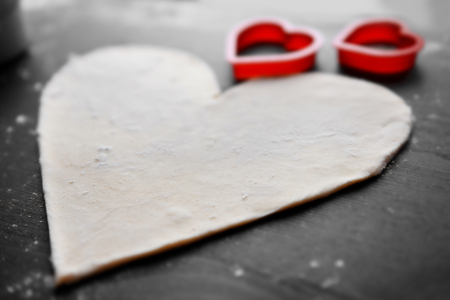 Uncooked heart shaped biscuit on a tableの写真素材