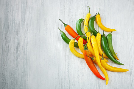 Yellow chili peppers on light wooden backgroundの写真素材