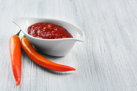 Homemade hot sauce and spices on light wooden backgroundの写真素材